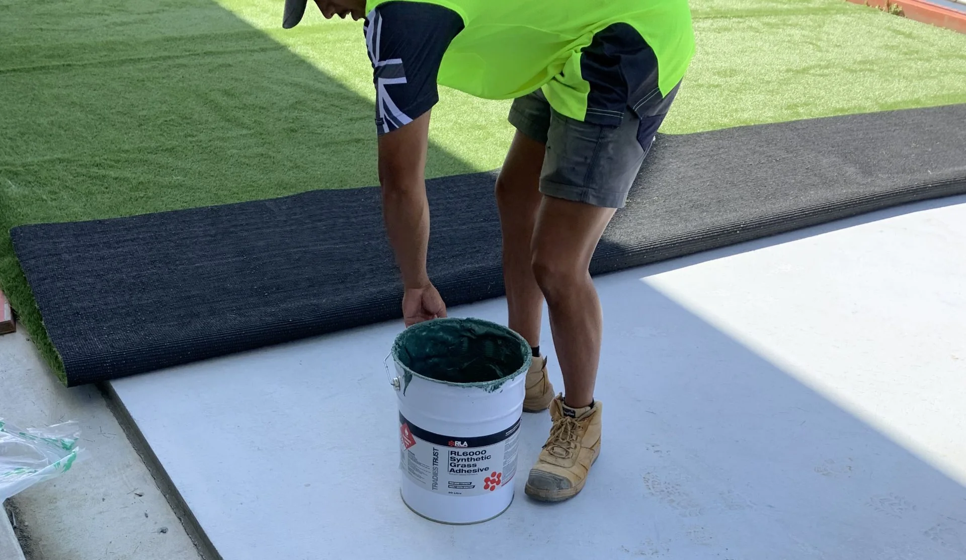man picking up RLA RL6000 synthetic grass adhesive