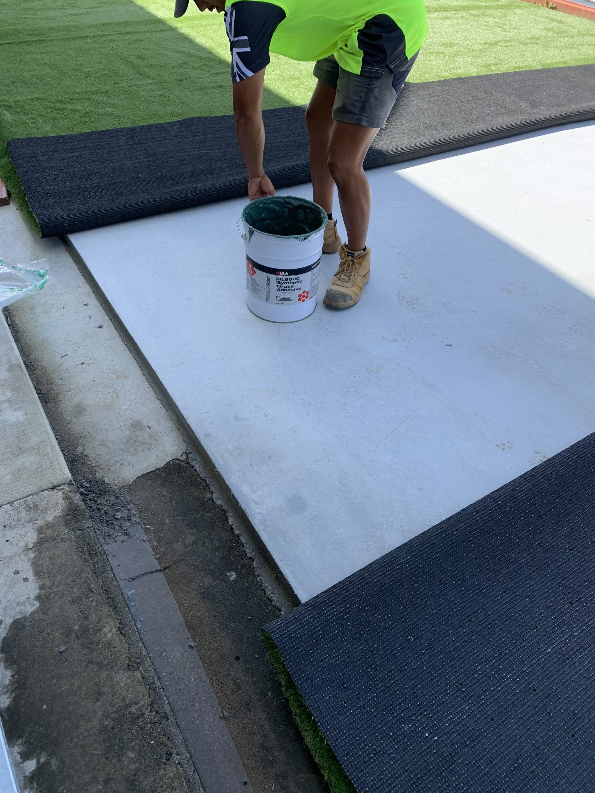 man picking up RLA RL6000 synthetic grass adhesive